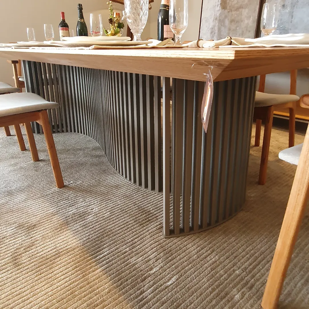 Mesa de jantar em madeira com base ripada escura e tampo natural